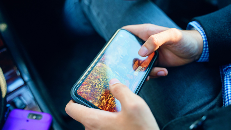 Person sitting while holding smart phone