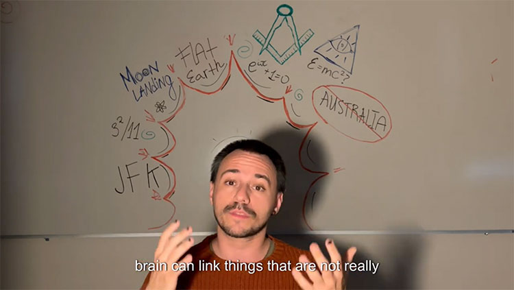 Man in front of white board with conspiracy theories