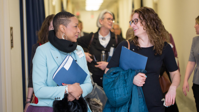 Image of two women walking and talking together.