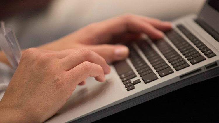 Image of a person typing on a keyboard.