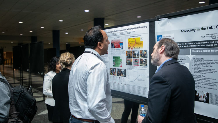 Two men at the SfN annual meeting discussing ways to advocate for Neuroscience.
