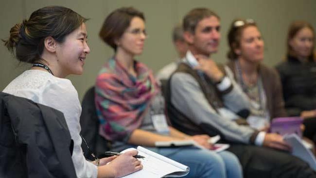 A female takes notes on staying organized during a workshop. 