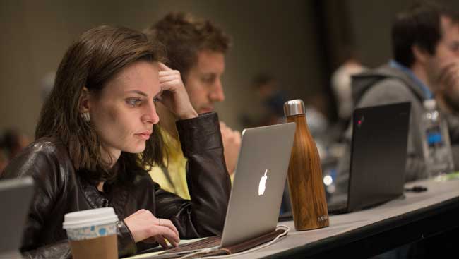 Woman Focused on Laptop in Lecture Hall
