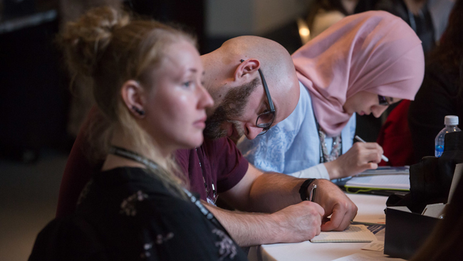 Neuroscience 2017 attendees taking notes at a table