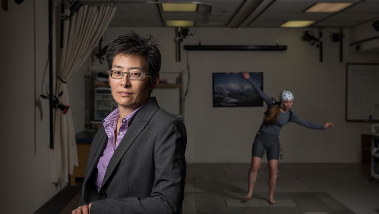 A former undergraduate researcher in the Neuromechanics Lab, Alix Macklin, wears an EEG system while losing her balance on a moving platform. Photo Credit: Georgia Tech.