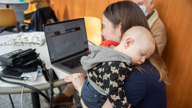 A woman holds her baby while attending Neuroscience 2023 in Washington, D.C.