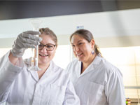 Naomi Lee and Noelle Waltenburg (BS, Chemistry, 2020) examine the contents of a test tube.