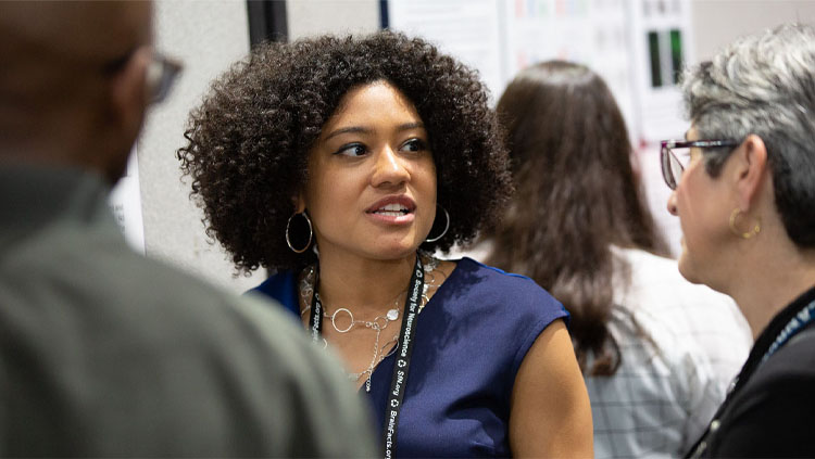 A woman explains her science to onlookers.