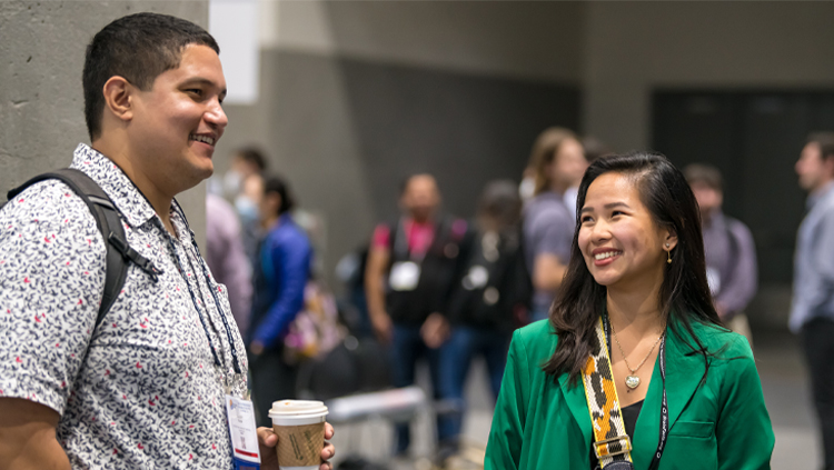 A young and a man woman talk at Neuroscience 2023 in San Diego.