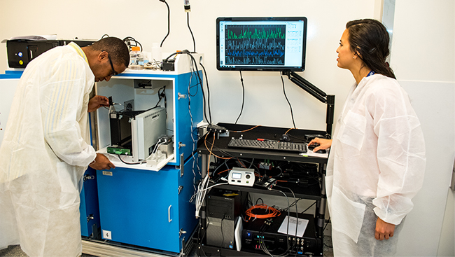 Scientists in the lab looking at a computer monitor