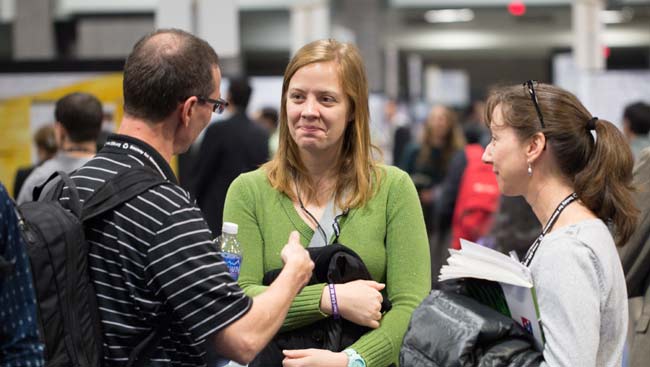 A male scientist gives his pitch to colleagues at a networking event. 