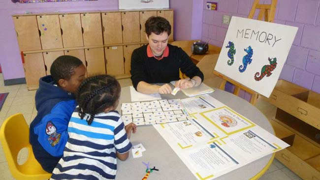 A male scientist explains his science to two children. 