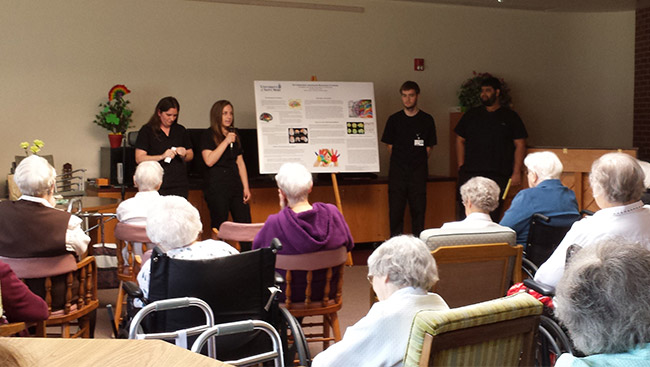Male and female neuroscience students give a presentation on healthy brain habits to the community. 