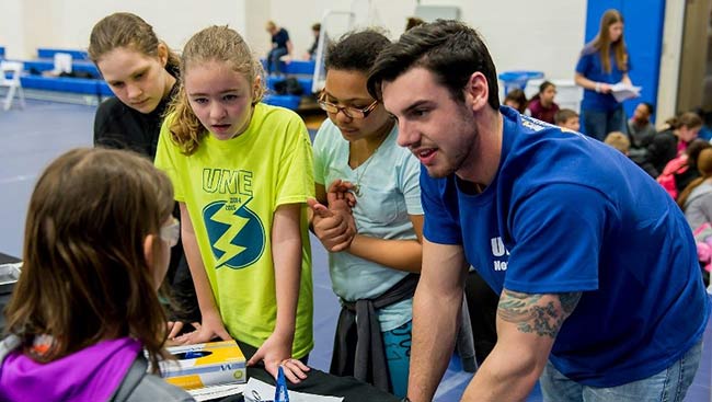 A group of students explain neuroscience concepts to another student