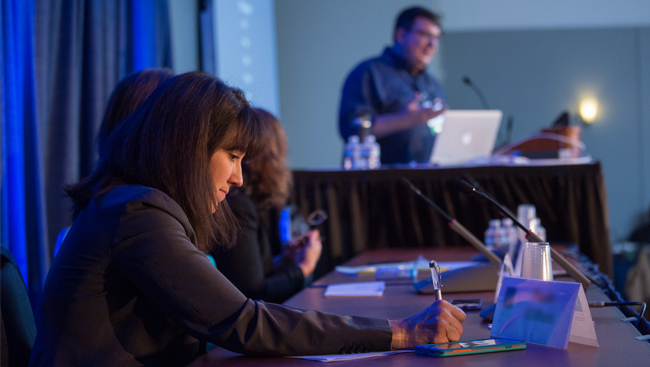 Panelists listen as a man speaks at the podium during the Animals in Research panel from Neuroscience 2017