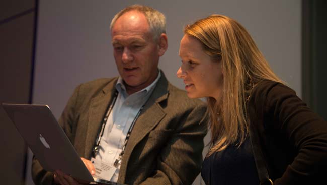 A male and female look over a reviewed manuscript. 