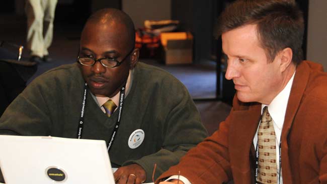 Two male neuroscientists share a computer screen. 