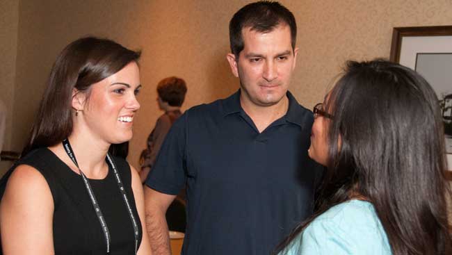 Three neuroscientists network at an event. 