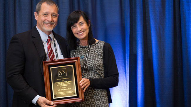 Julio Ramirez accepts award from Mara Dierssen