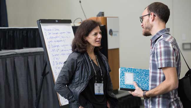 Two researchers have a discussion after a lecture. 