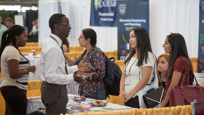 Neuroscientists network at a graduate school fair. 