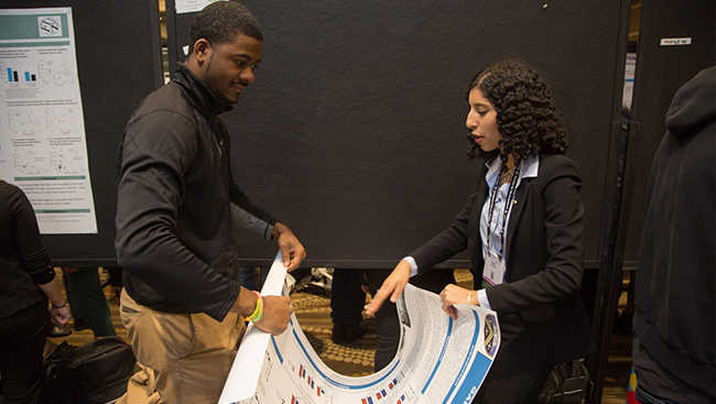 Attendees assisting each other on the poster floor at Neuroscience 2017.
