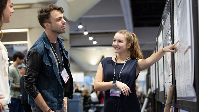 Presenter discussing on the poster floor at Neuroscience 2018.