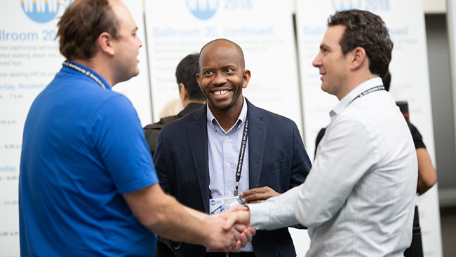 Attendees shaking hands at Neuroscience 2018.