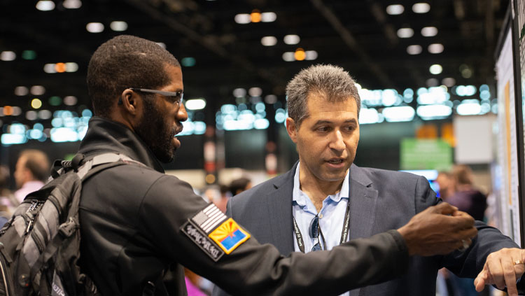 Two men discuss a poster at Neuroscience 2019