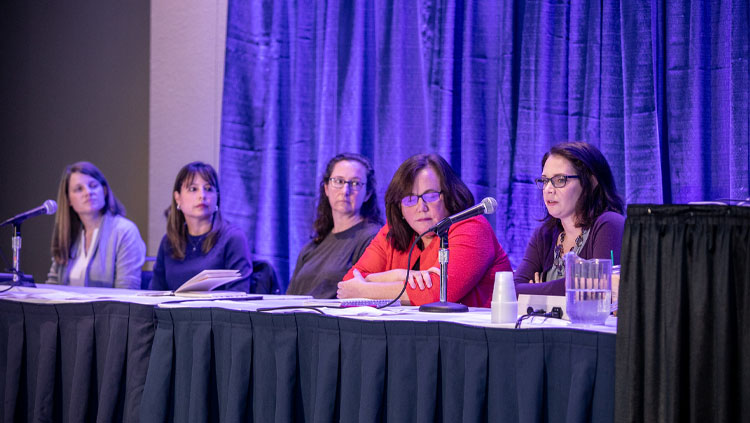Five female panelists sit at a table while speaking at the Neuroscience Departments and Programs Workshop - Hiring and Promoting Faculty in the Era of Team Science.