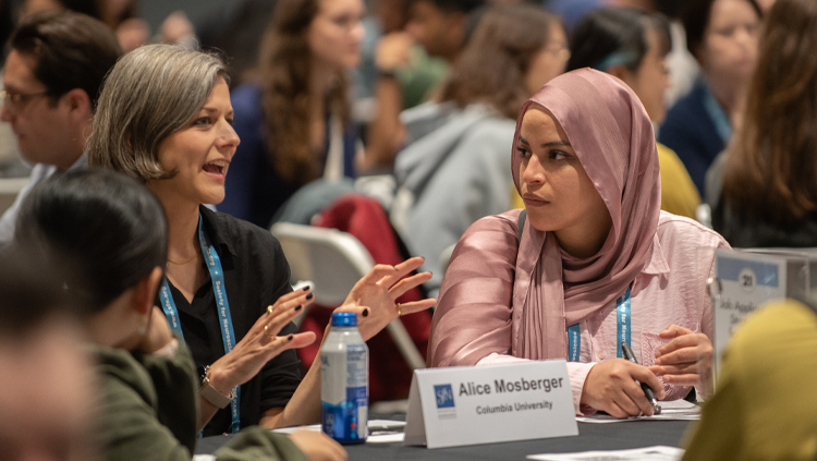 Two people converse at Neuroscience 2024.
