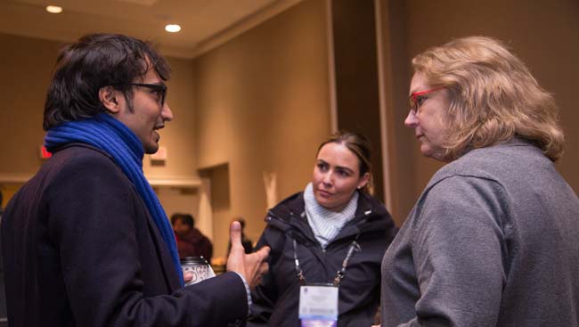 Two female and one male scientist network at a conference. 