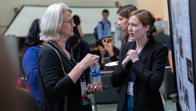 Image of two women discussing a poster at Neuroscience 2018