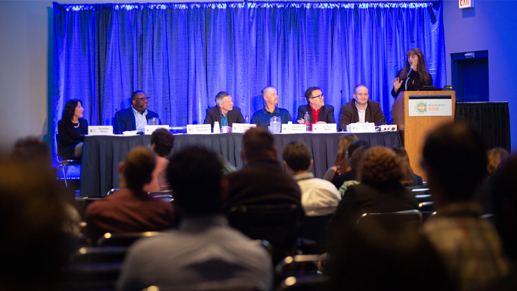 Seven panelists sit at a table discussing social issues at Neuroscience 2019