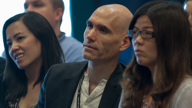 Male and female neuroscientists listen to a talk.