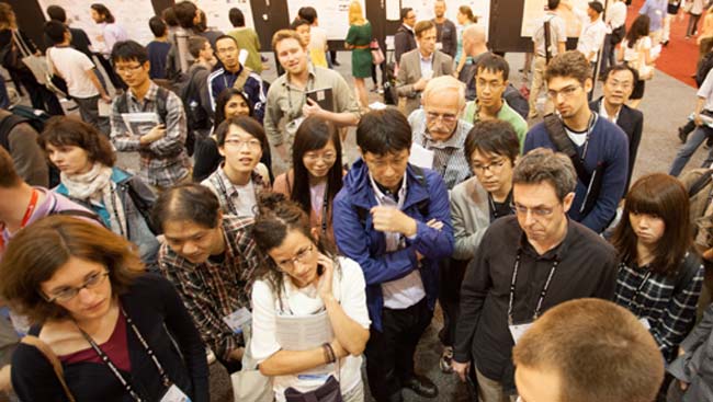 Male and Female scientists look at a poster. 