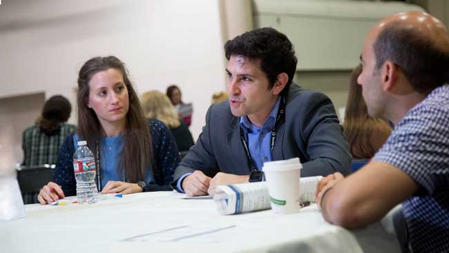Female and male neuroscientists share ideas at a networking event. 