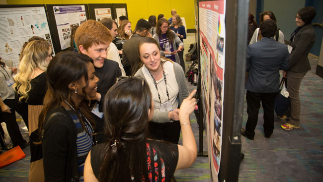 Undergraduate neuroscientists discuss a poster during a conference. 