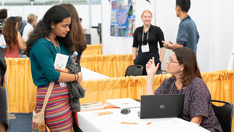 Neuroscience 2018 attendee listening to an exhibitor at the Grad School Fair.