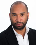 Headshot of Mathew Abrams wearing a white button down shirt with a black jacket.