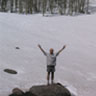 Image of Atomu Sawatari standing on a rock in a field of snow.